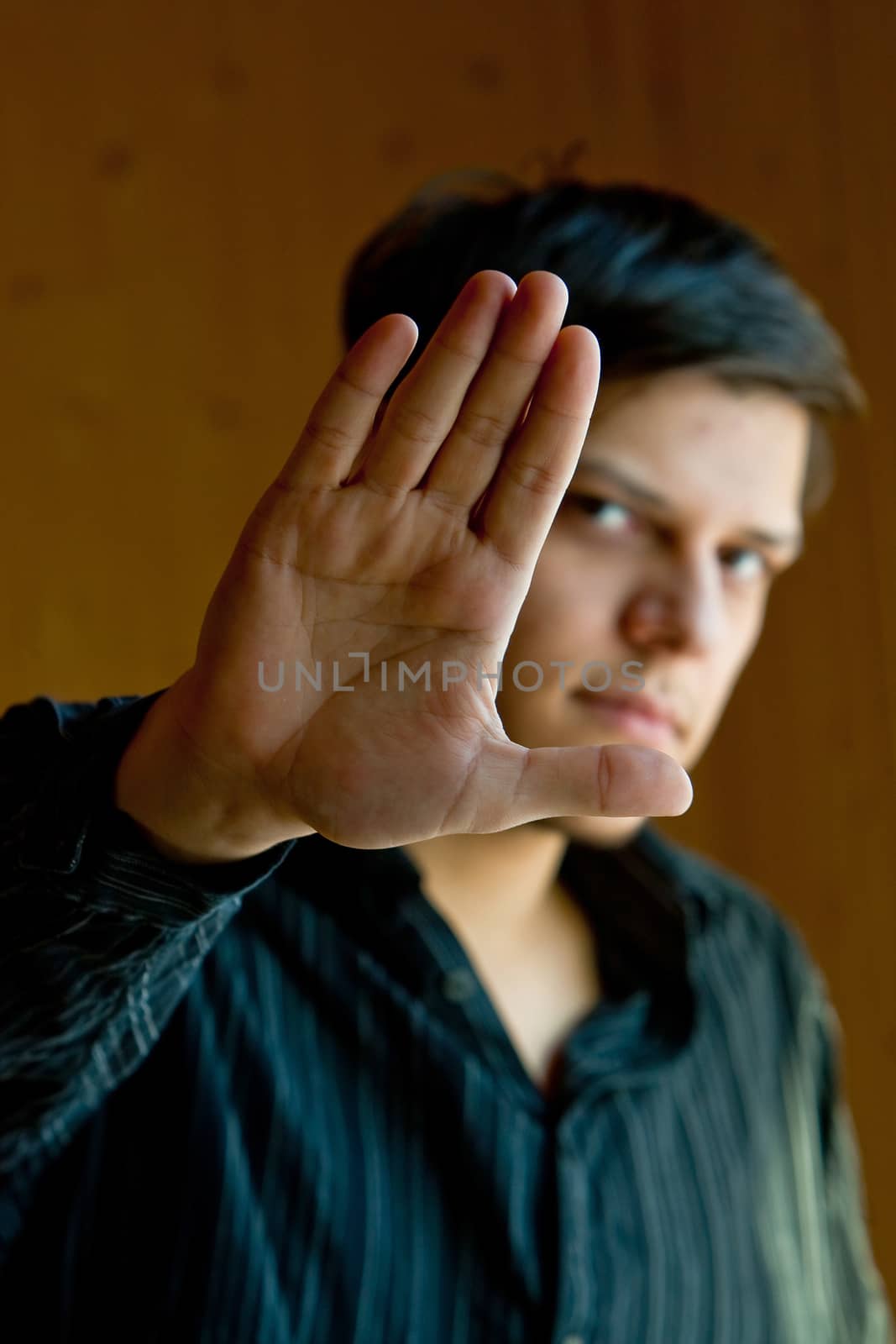 Young man showing a sign "stop"