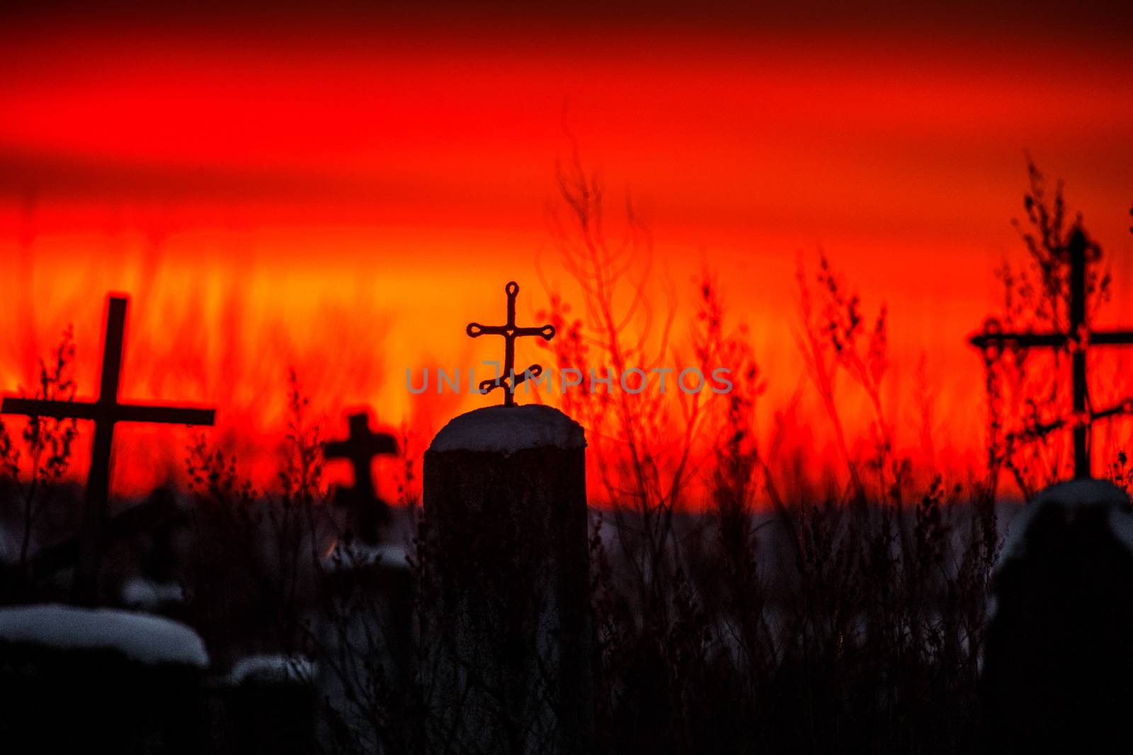 Christian cross silhouette with the bloody sunset as background