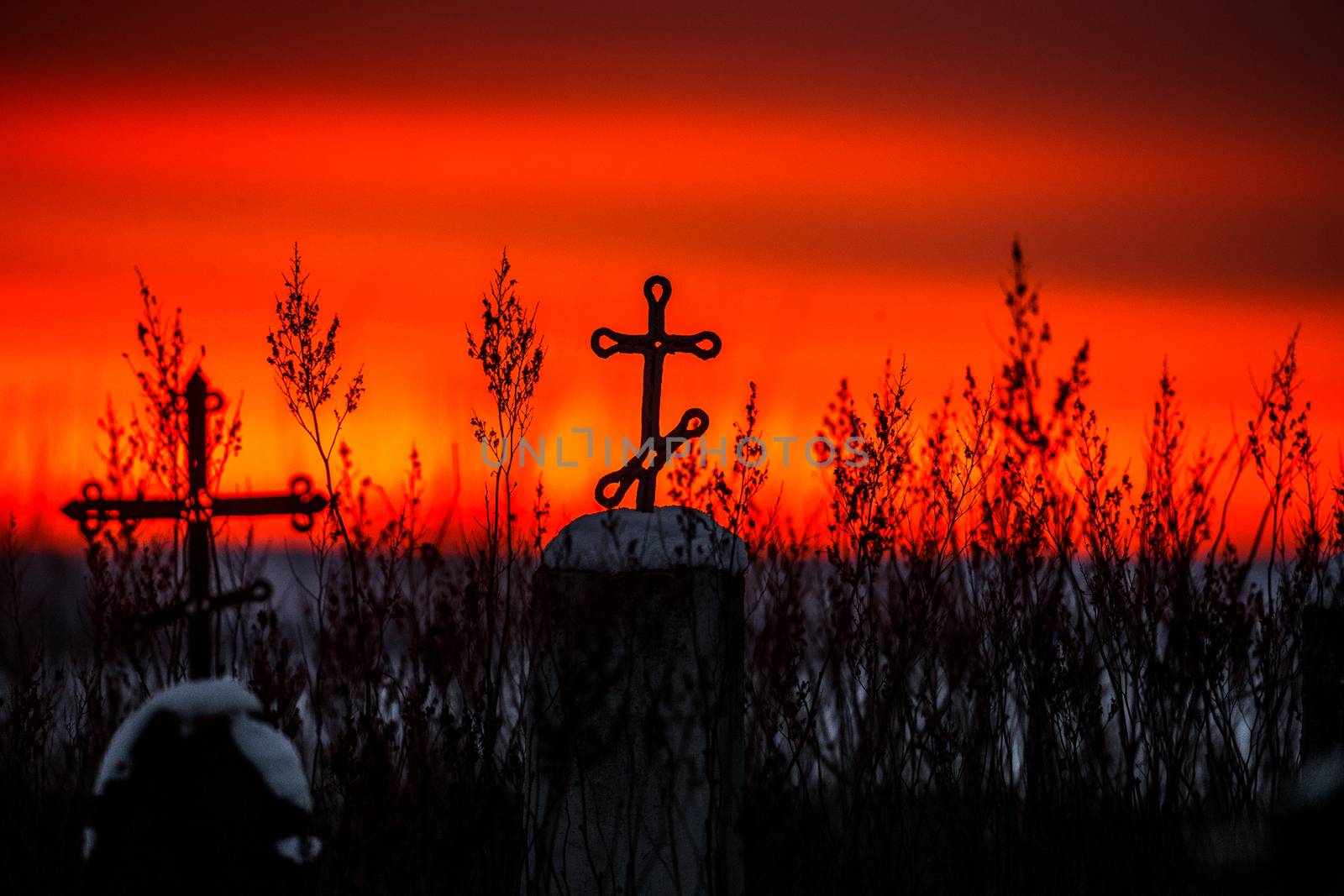 Christian cross silhouette with the bloody sunset as background