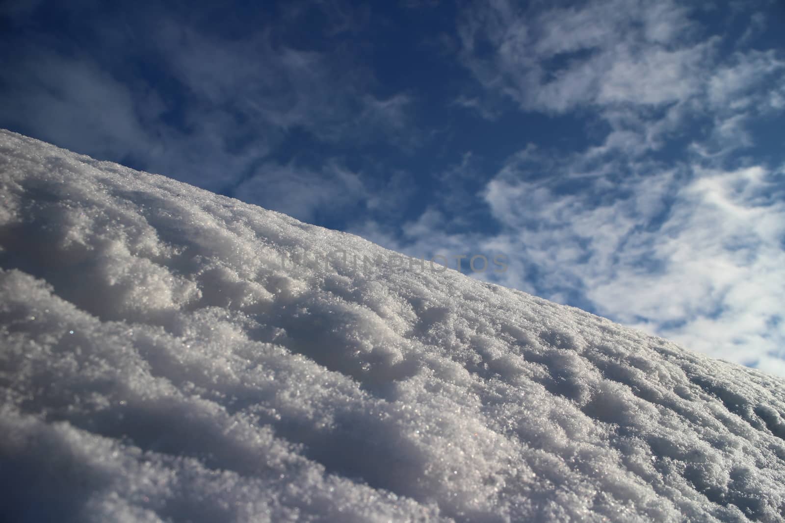 mountain covered with white fluffy snow against the blue sky low angle view
