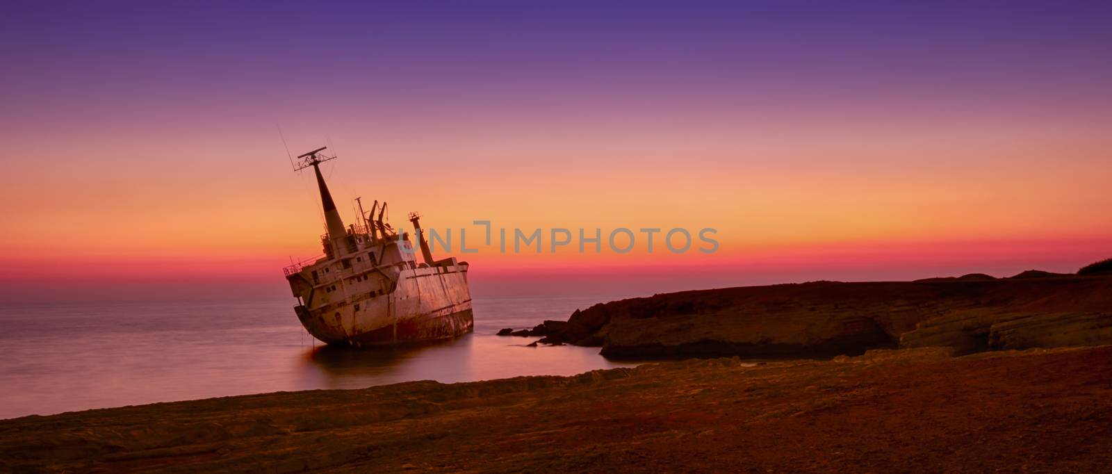 Seascape: famouse boat, shipwrecked near the rocky shore at the sunset. Mediterranean, near Paphos. Cyprus.