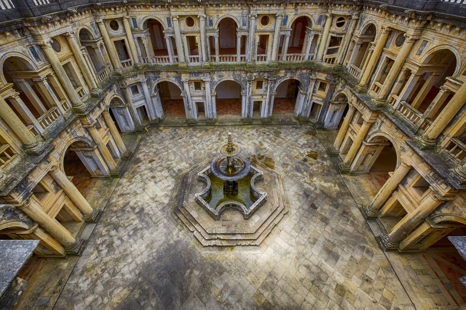 Beautifully preserved castle - palace of the Templars. Courtyard surrounded by galleries. In the center - a fountain with a pool in the shape of a cross. Portugal, Tomar.