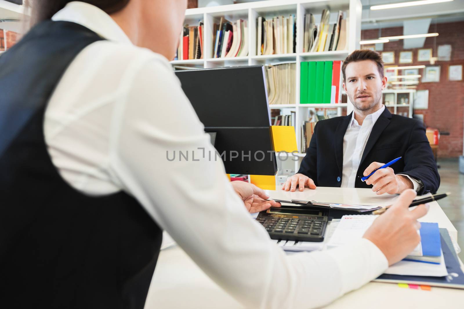 Two business people working with reports sitting at the table