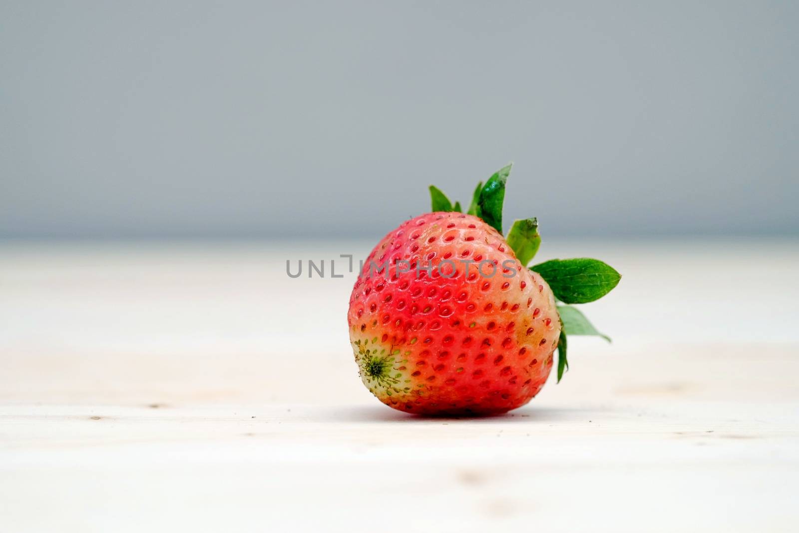 One Red Strawberry on the Table Wood