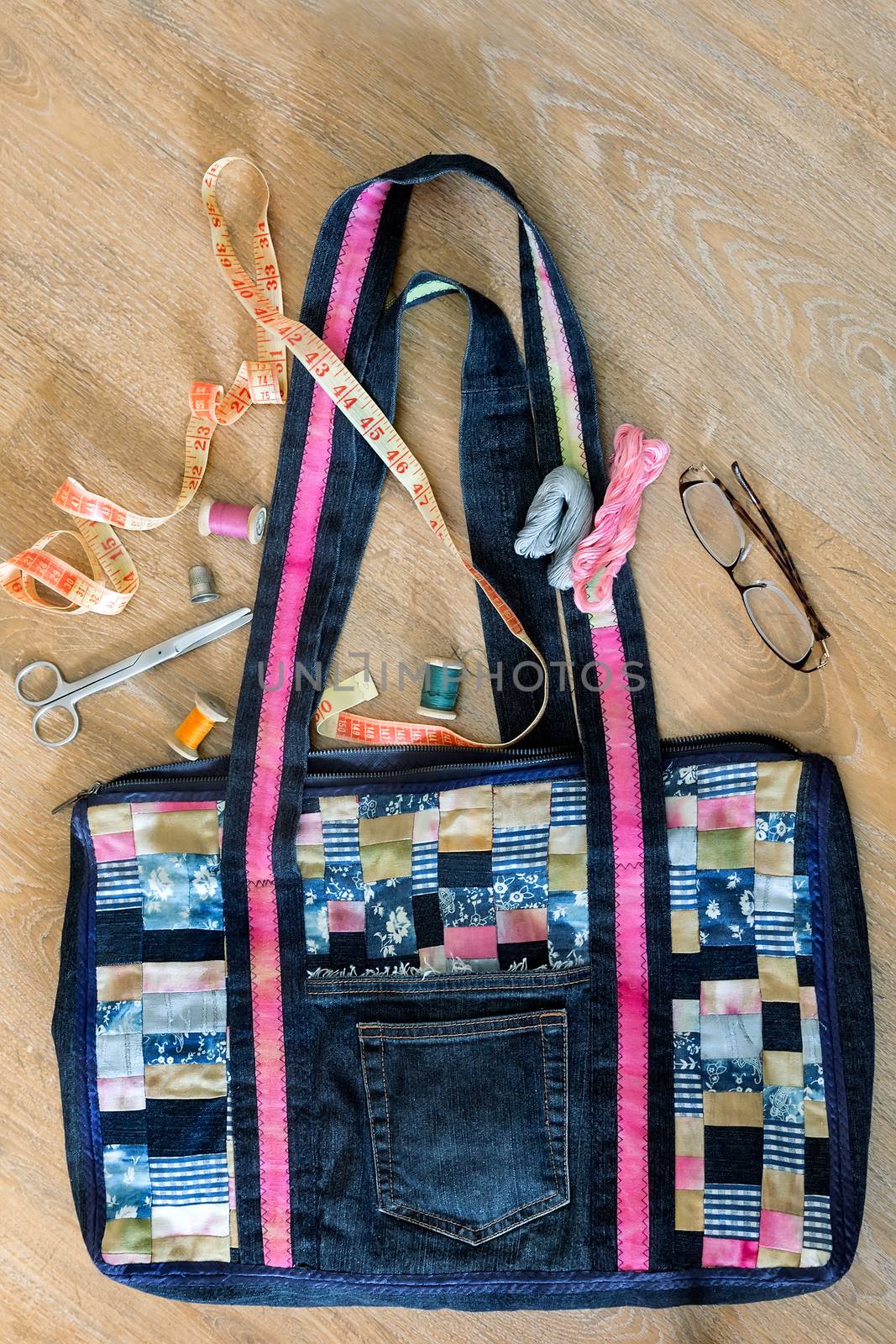 Beautiful female bag of colorful scraps of fabric in patchwork. Handmade. Next are the threads, needles, scissors, inch.