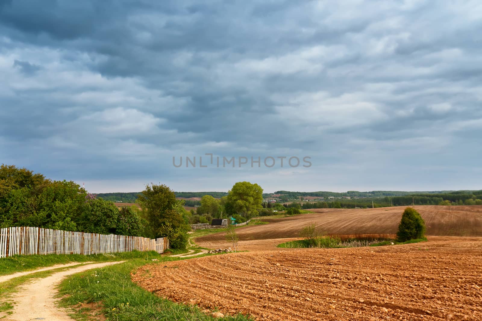 Spring storm clouds above country road by weise_maxim