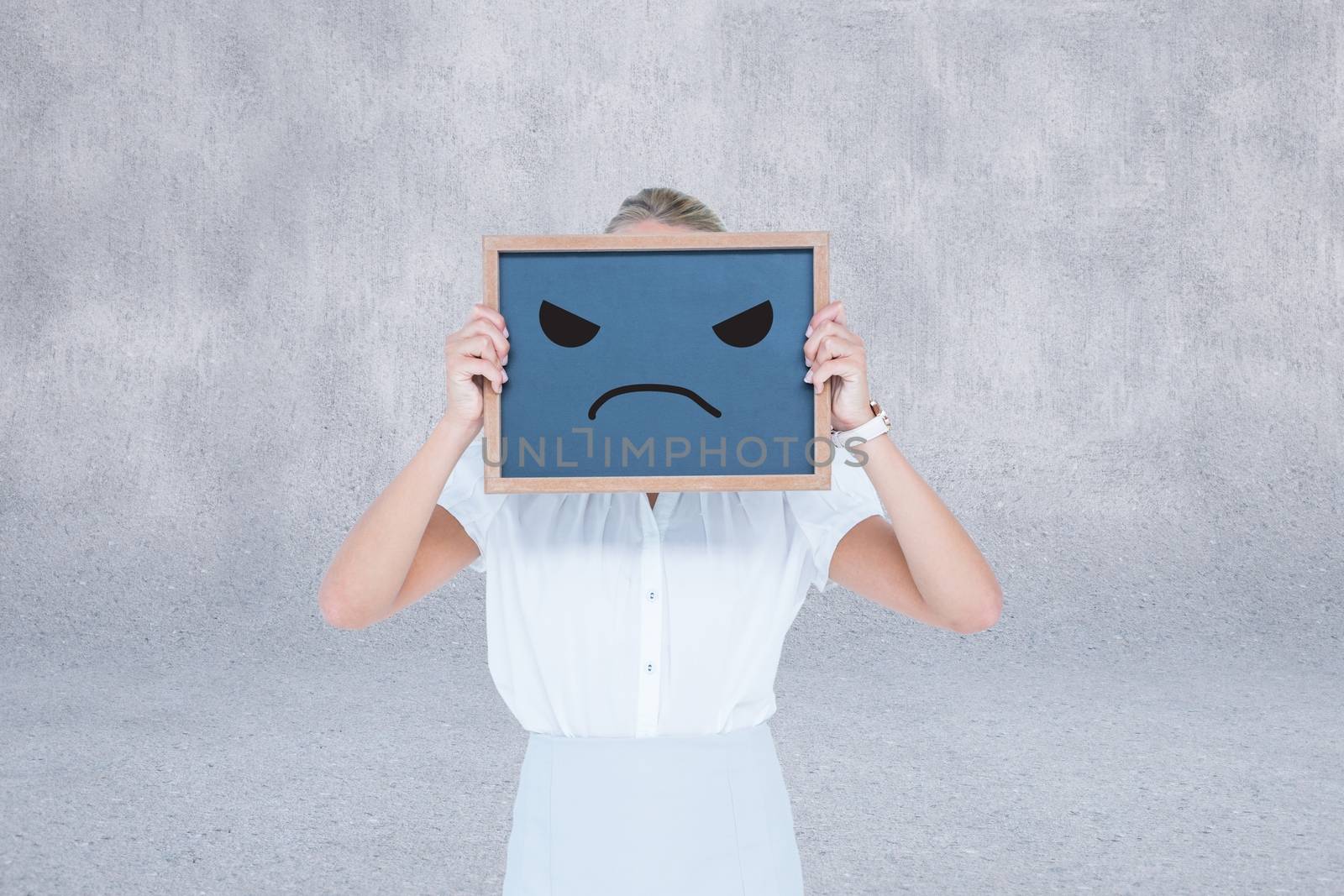 Composite image of woman is holding a chalkboard with unsmiling figure against a grey background