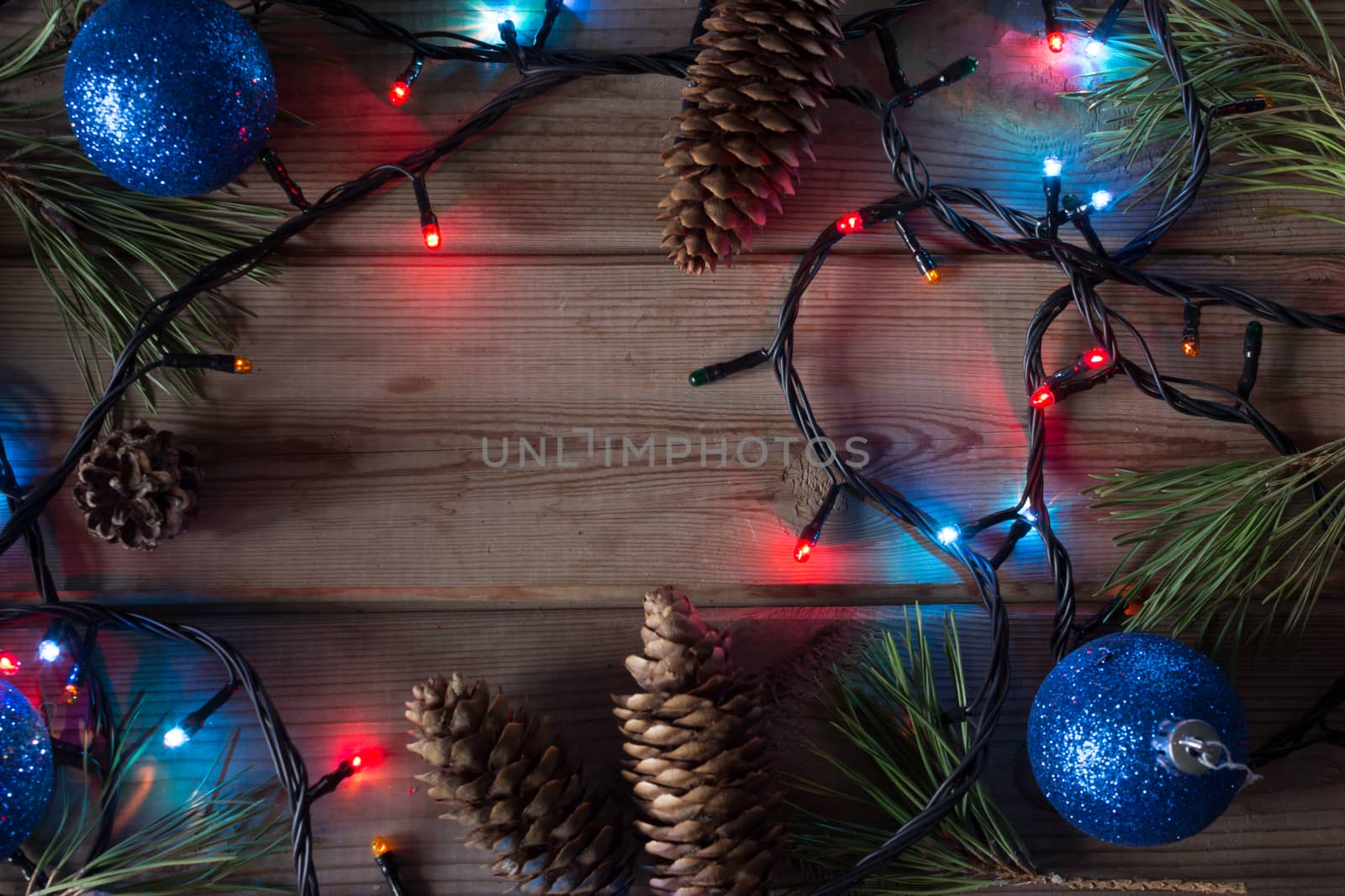 Christmas tree garland, Christmas tree branches and Christmas balls on wooden table mock up