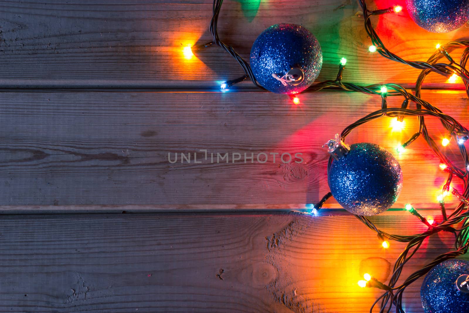 Christmas tree garland, Christmas tree branches and Christmas balls on wooden table mock up