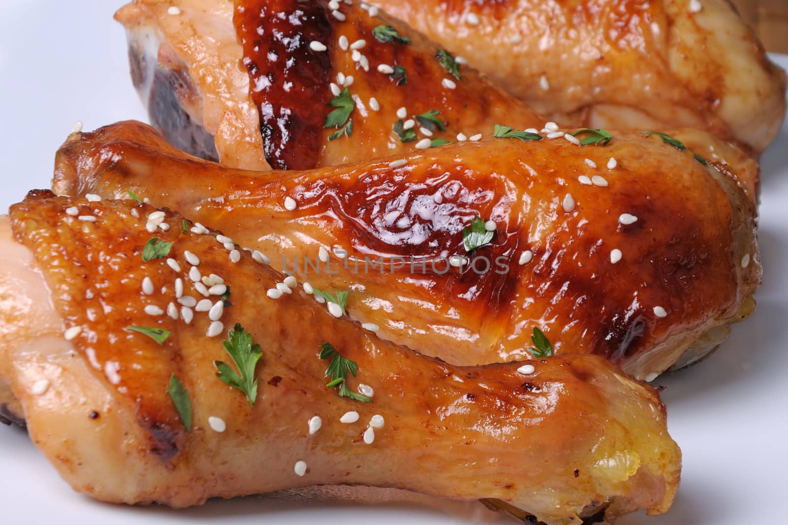 Fried chicken leg with sesame seeds in a plate closeup