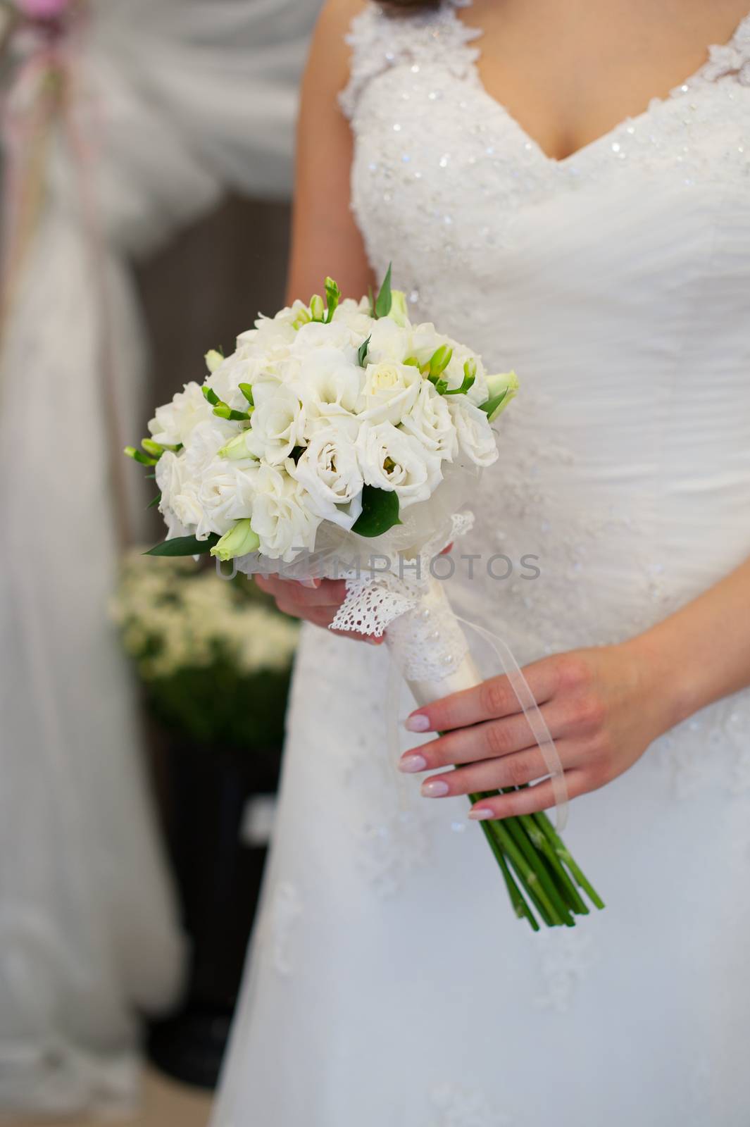 Bride holding beautiful wedding bouquet on walking time.
