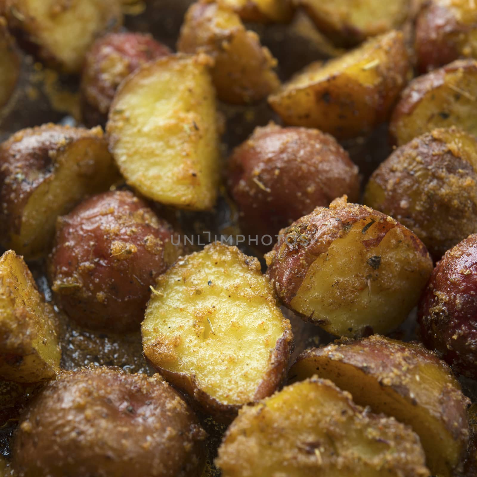 Top view close up freshly oven baked baby potatoes on wooden table, low light setting.
