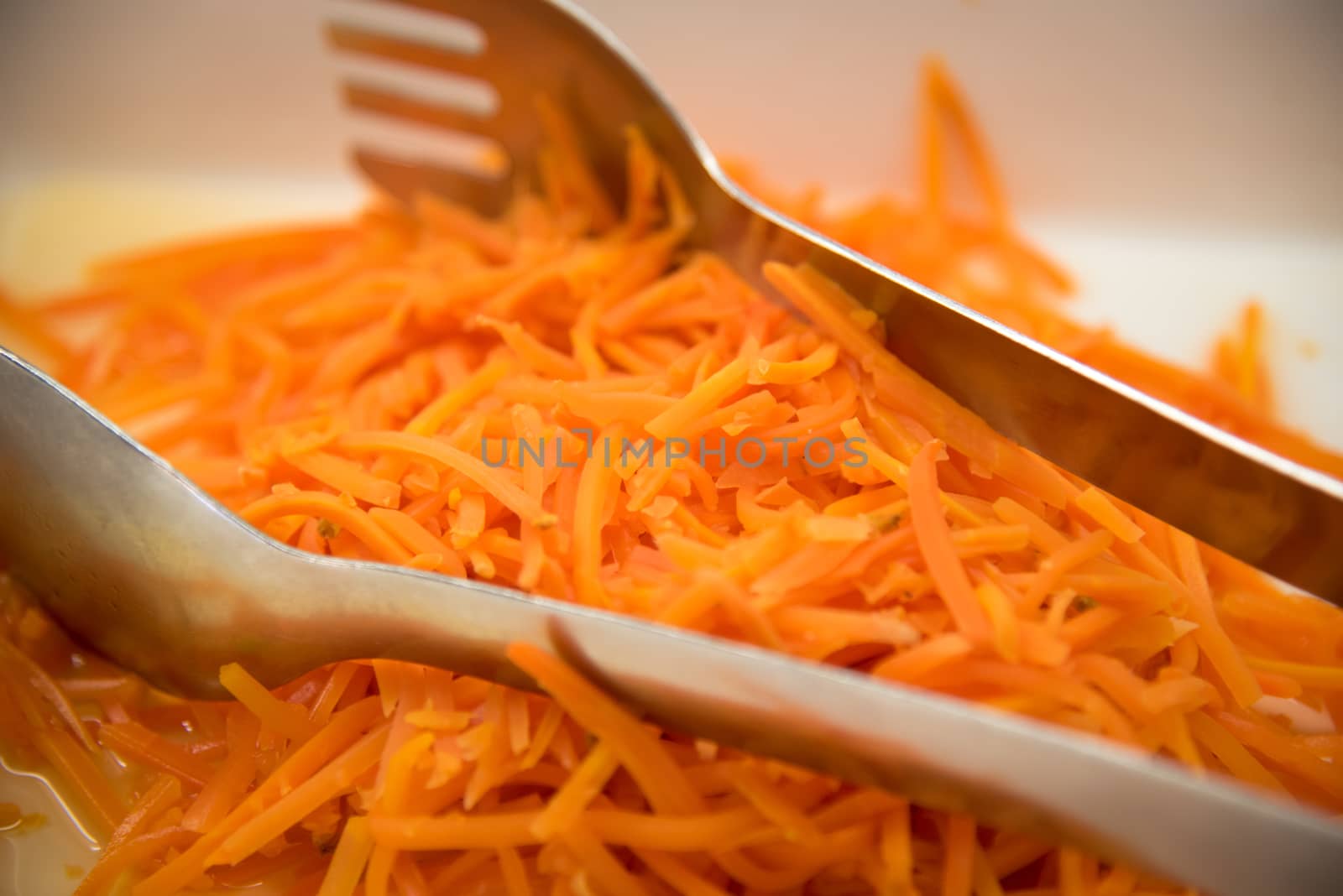 Tray of pickled carrots   and a large spoon .