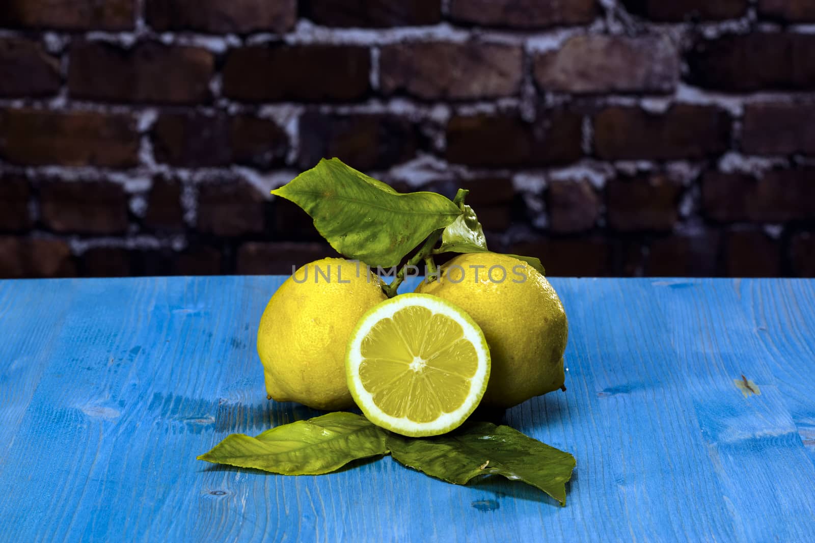 Acid and yellow fruit. Lemons on a blue wood, stock photo