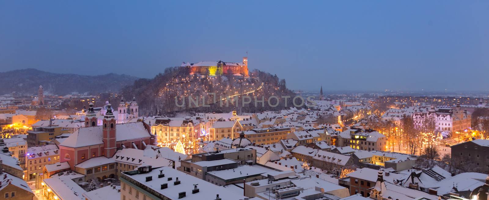 Aerial panoramic view of Ljubljana decorated for Christmas holidays. Roofs covered in snow in winter time. Slovenia, Europe.