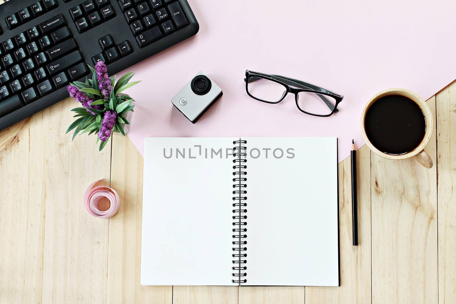 Business concept : Flat lay style of office workspace desk with blank notebook paper, computer keyboard, cup of coffee and accessories, top view mock up