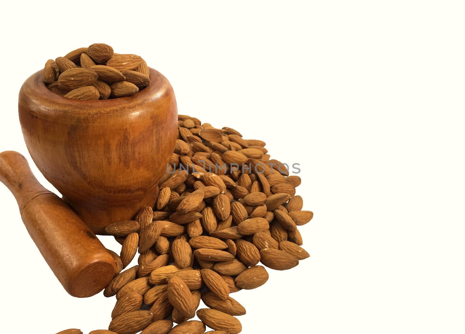 Closeup of almonds in wooden bowl on white background isolated.