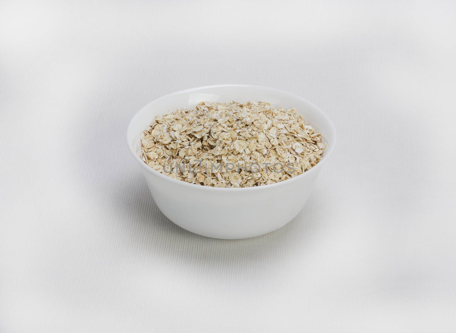 Bowl of oats porridge isolated on a white background Healthy breakfast