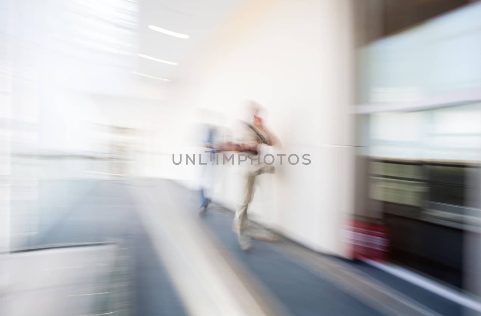 A motion blurred background image of an interior of hospital, airport or other with some human figures.