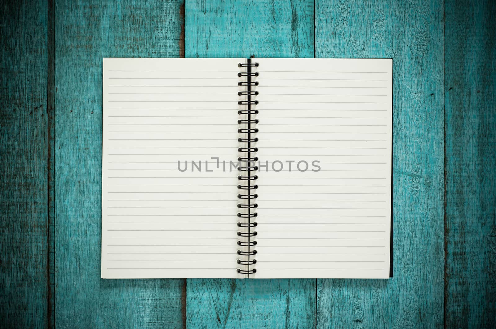 Blue wooden desk table with blank notebook. Top view with copy s by koson