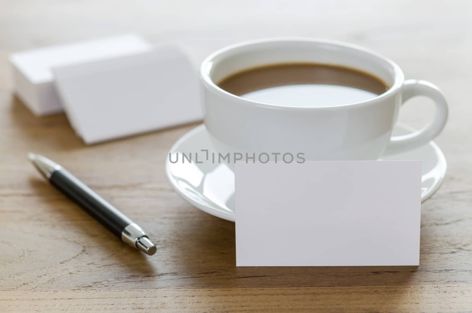 Blank business cards, pen and cup of coffee on wooden table. Corporate stationary branding mock up.