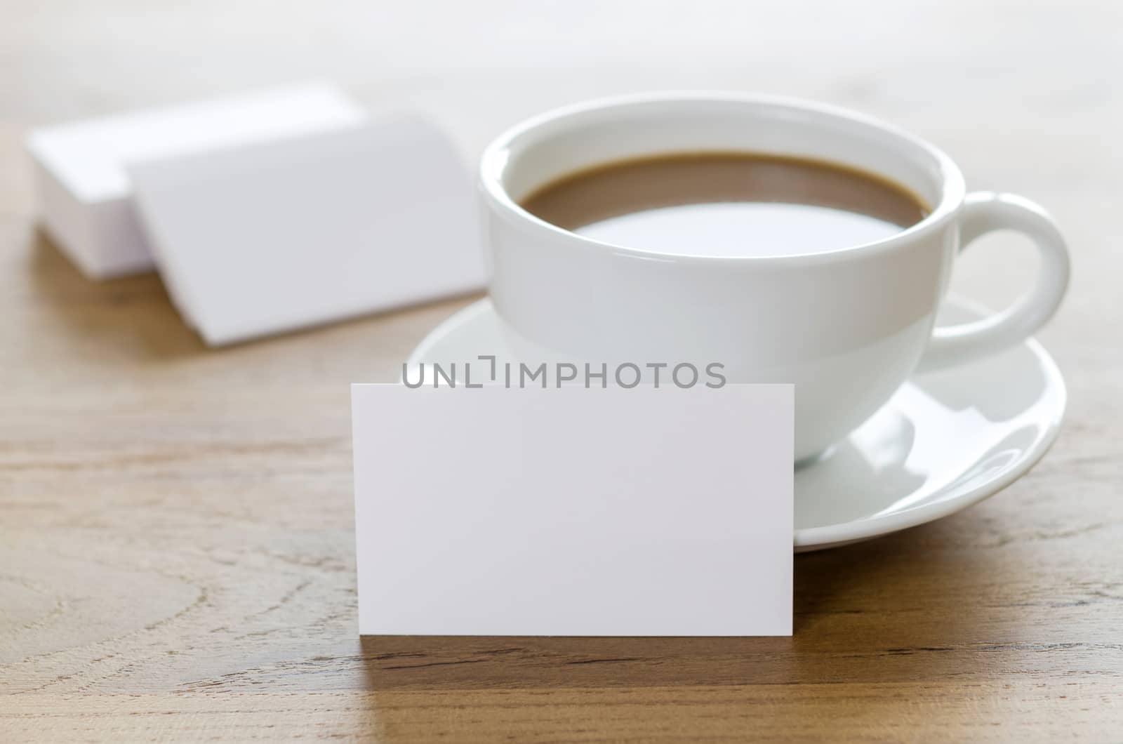 Blank business cards and cup of coffee on wooden table. by koson