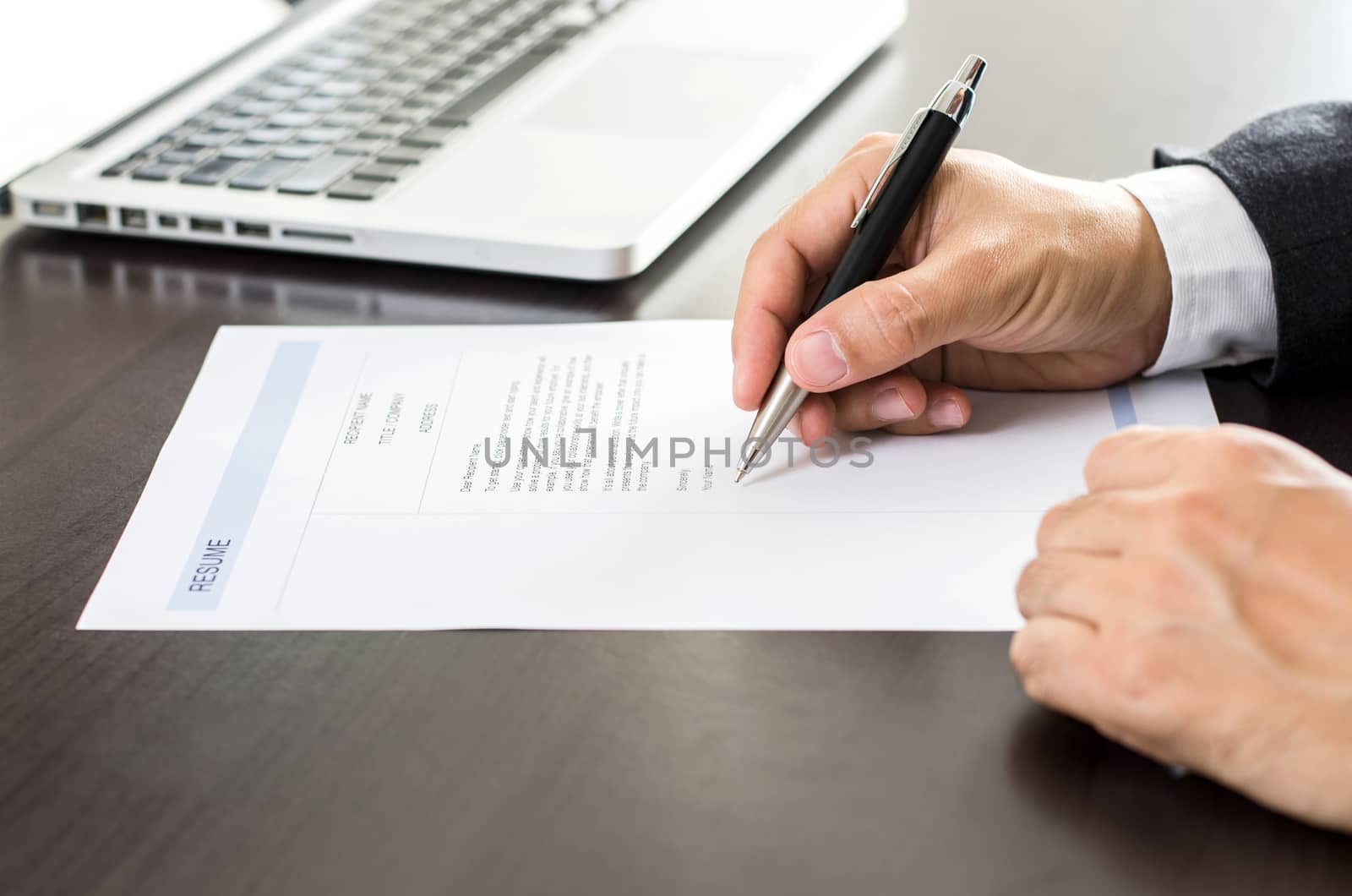 Close-up Businessman or job seeker signing on resume form.