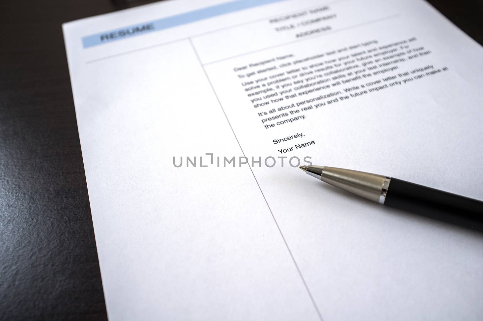 Close-up of resume and pen on black wooden desk. Business or job seeker concept.