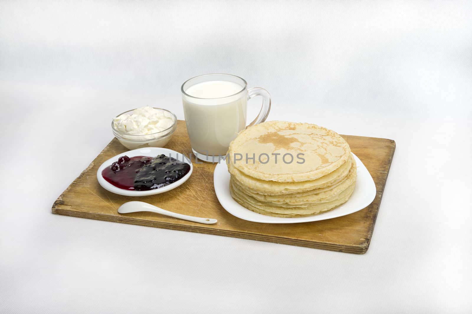 pancakes with jam and milk smeranoy on a wooden plank