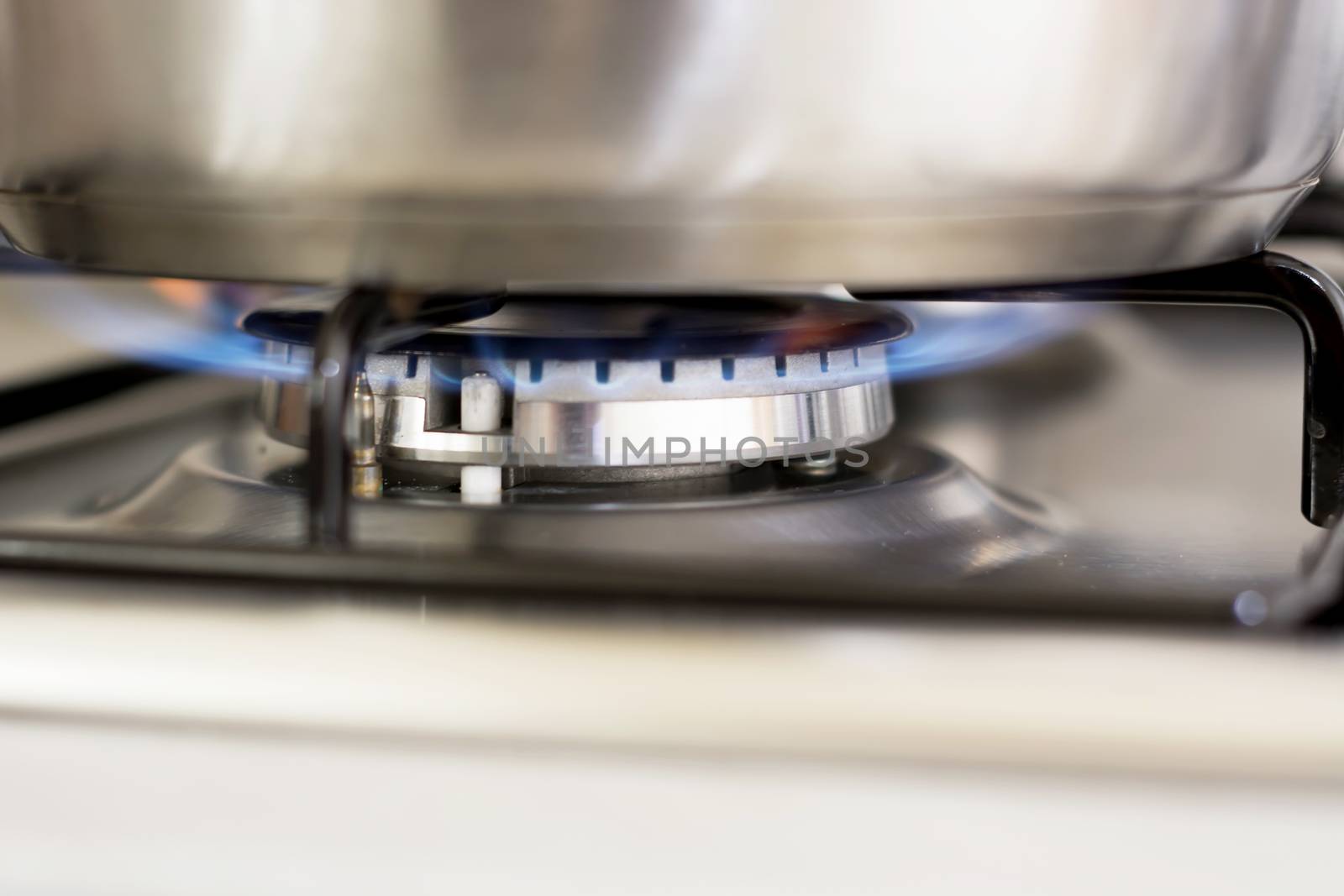 saucepan on burning gas in hearth ring of kitchen stove