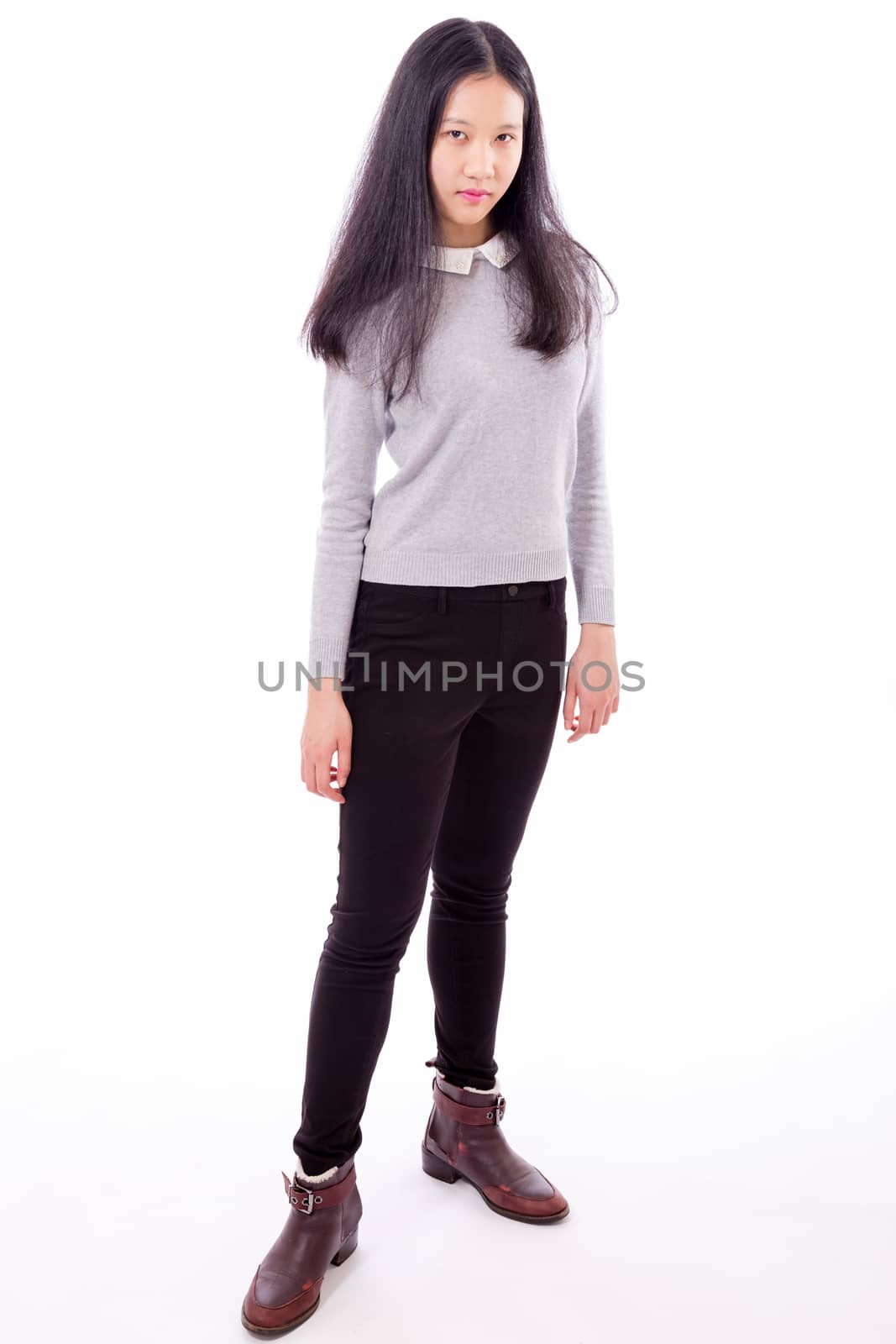 Standing Chinese teenage girl looking at camera, serious expression