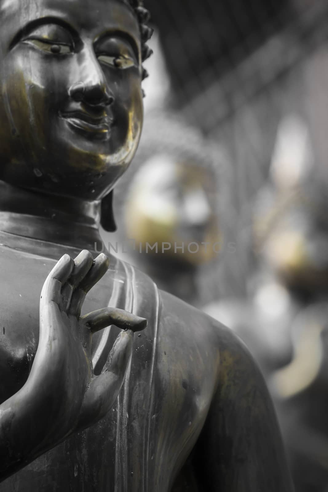 Row of Buddha statues at Ganagarama temple, Colombo, Sri Lanka. Black and white.Yellow selective colour.

