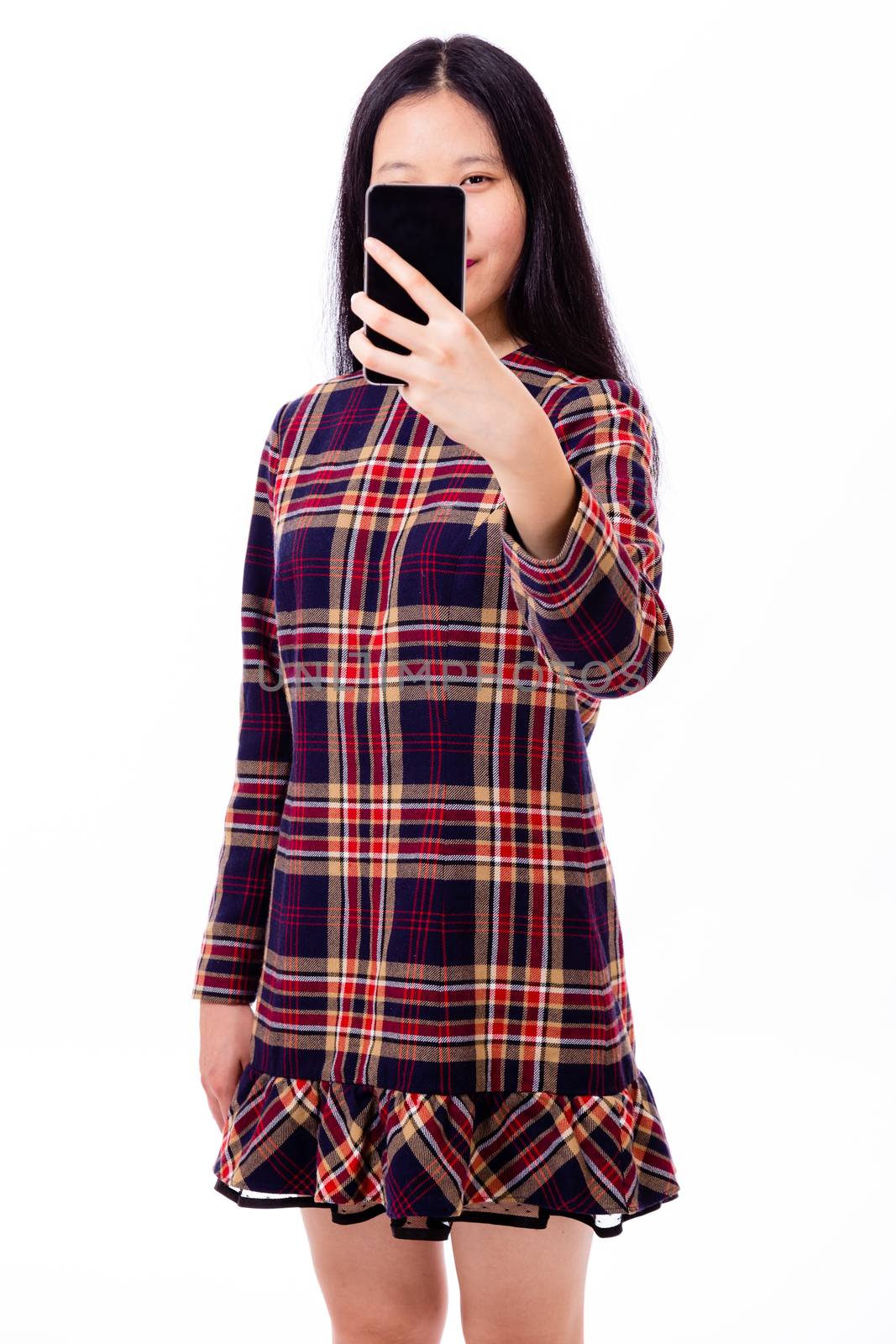 Chinese teenage girl in plaid dress taking selfie with smartphone