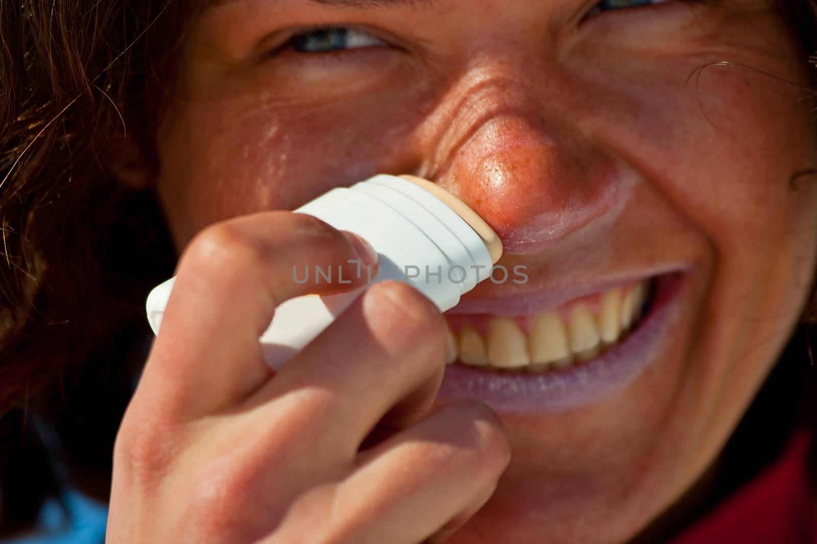 Close up of the nice girl, applicating the sunblock cosmetics.