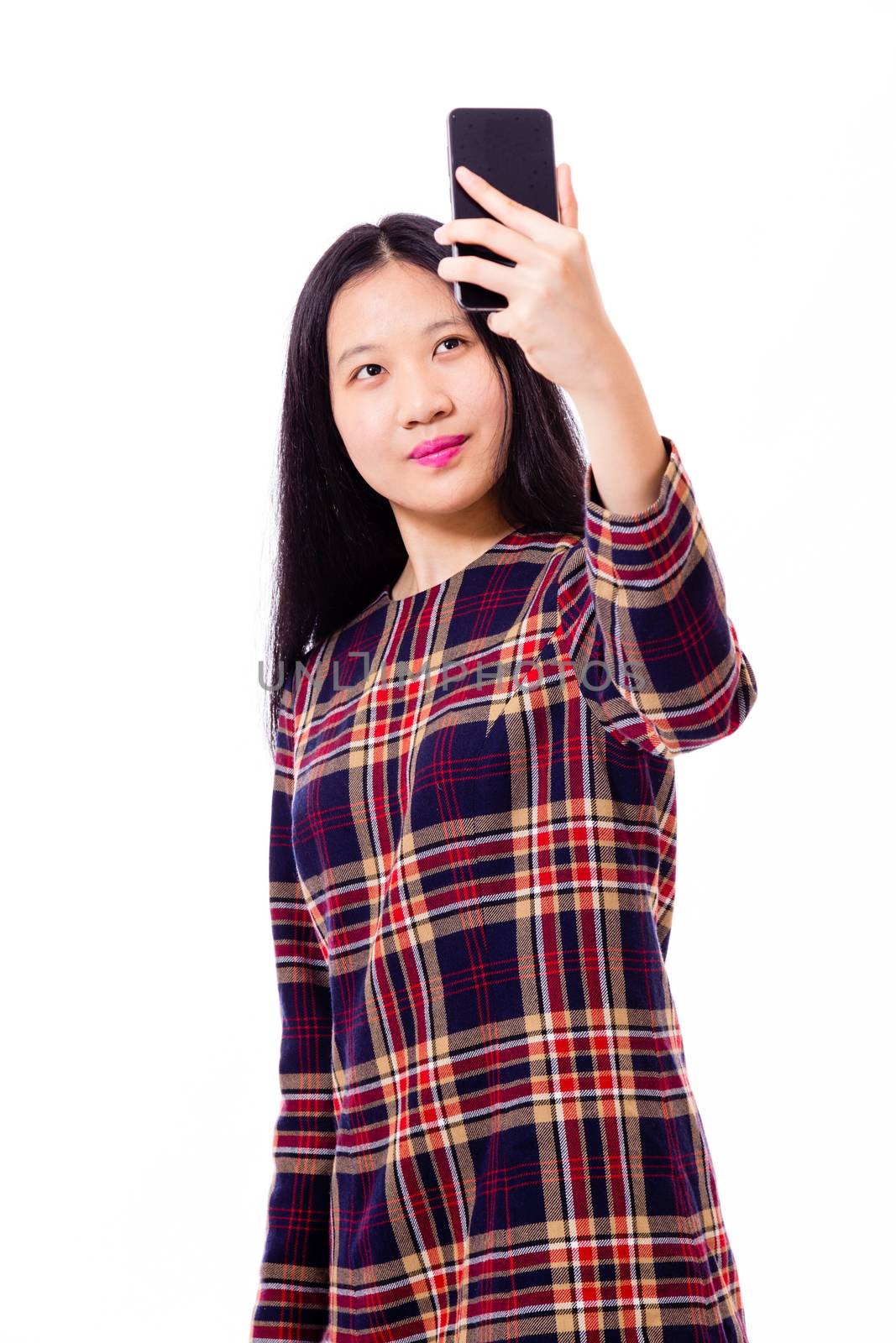 Chinese teenage girl in plaid dress taking selfie with smartphone