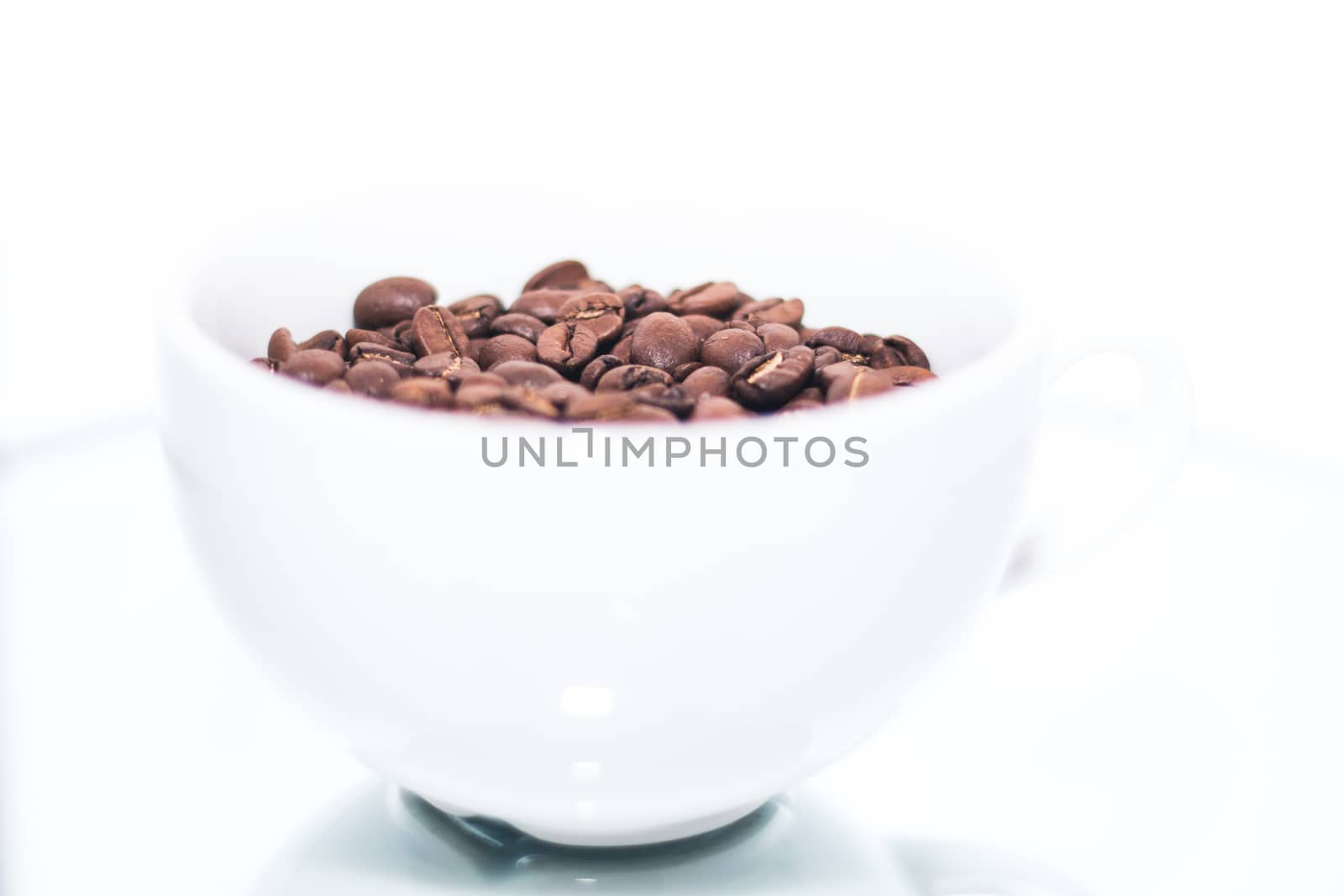 White cup with coffee beans inside