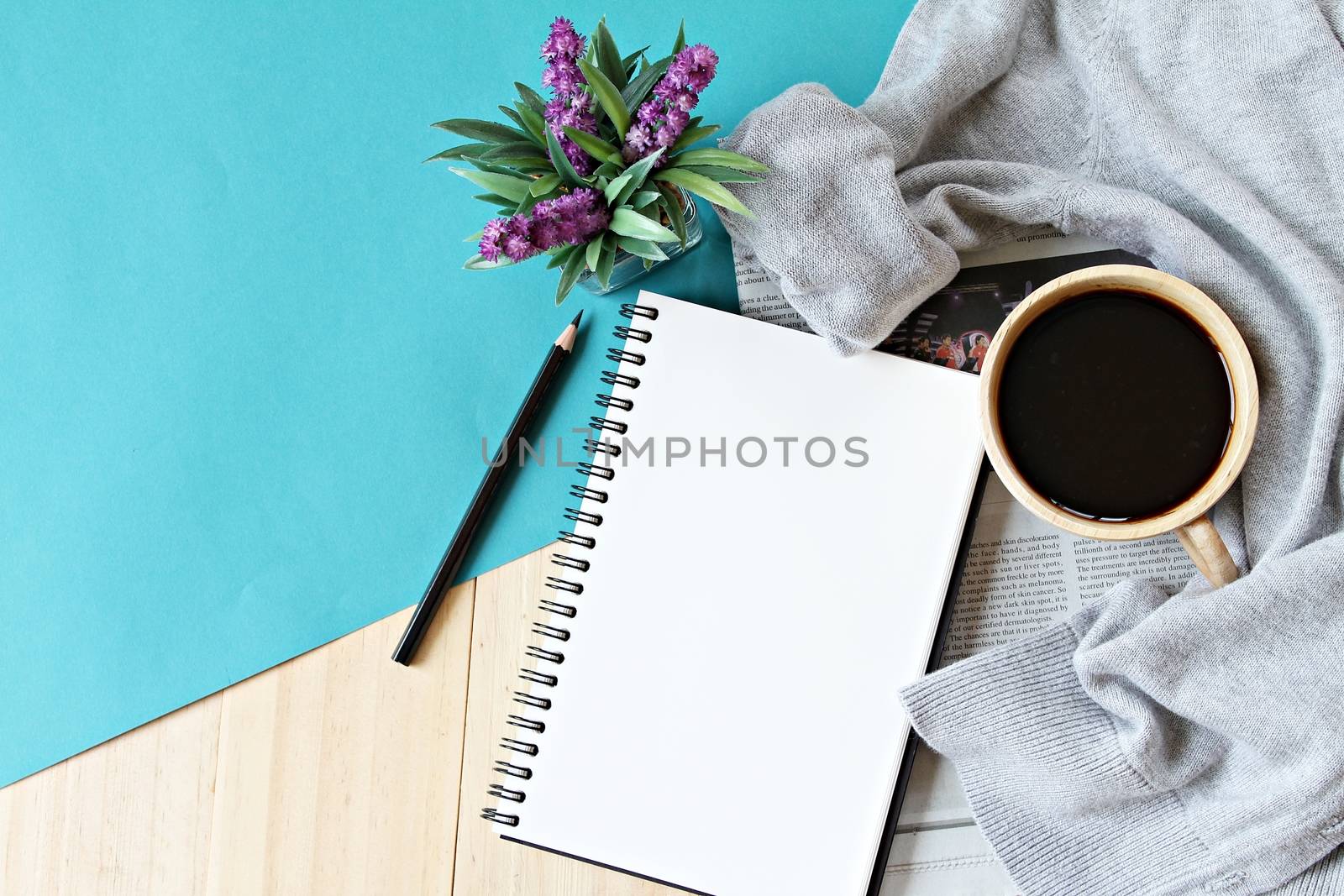 Business, Holiday or weekend concept : Flat lay of knitted sweater, cup of coffee and blank notebook paper on wooden background