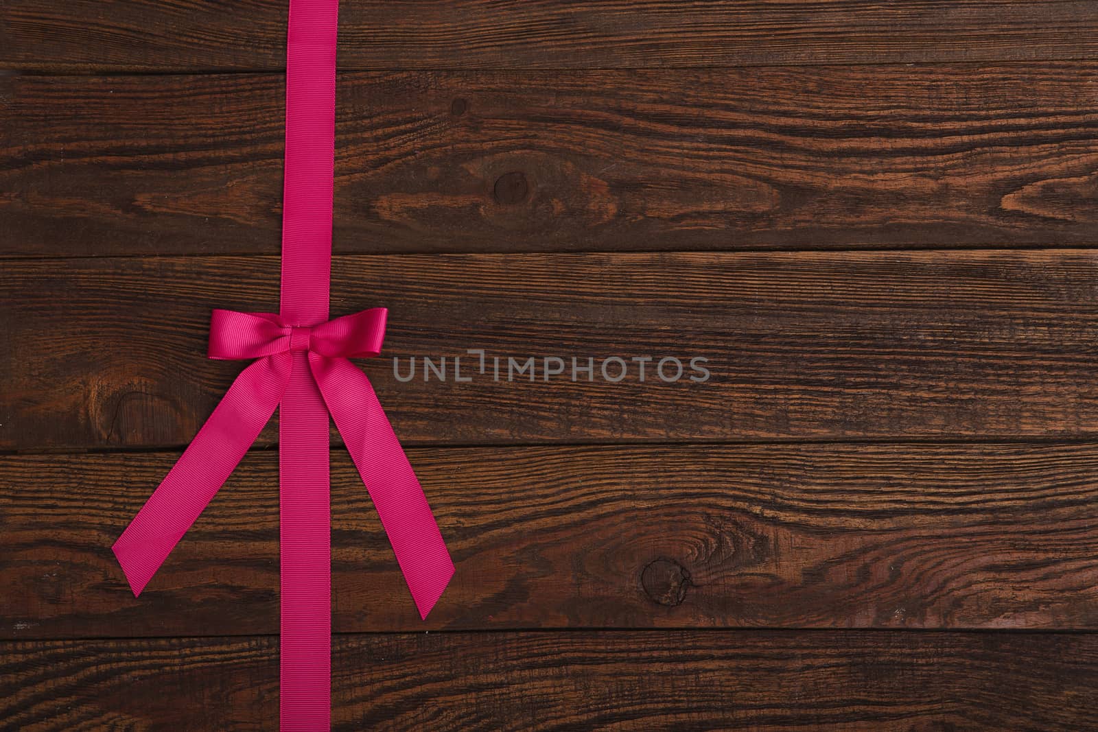 plank wood texture background with pink ribbon by natazhekova