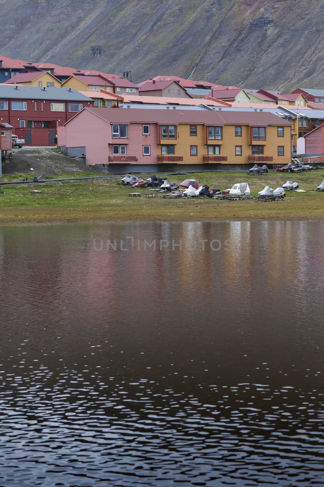 Idyllic scenic view, colorful houses and green field with arctic by mariusz_prusaczyk