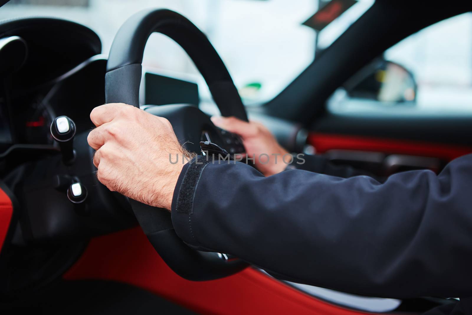 The male driver hands holding steering wheel