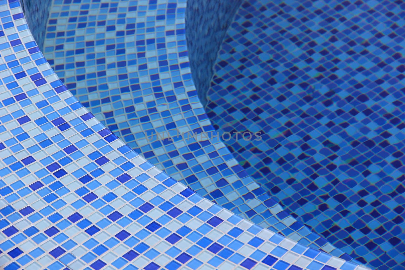 Curved steps at the swimming pool with blue tile mosaic