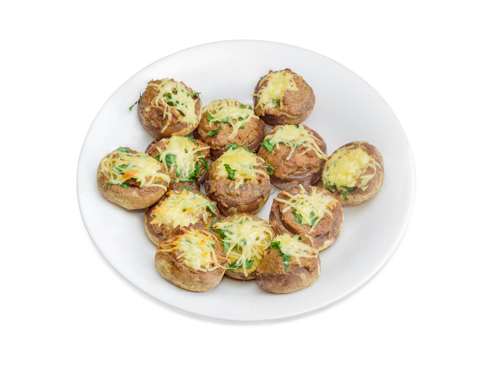Baked button mushrooms stuffed with minced meat, cheese and greens on the white dish on a light background
