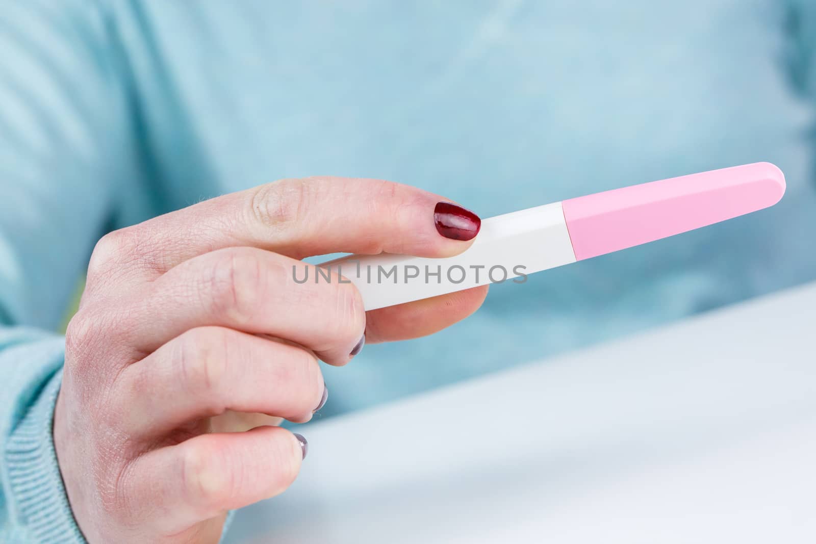 Young woman holding a Pregnancy Test in her hands by pixinoo