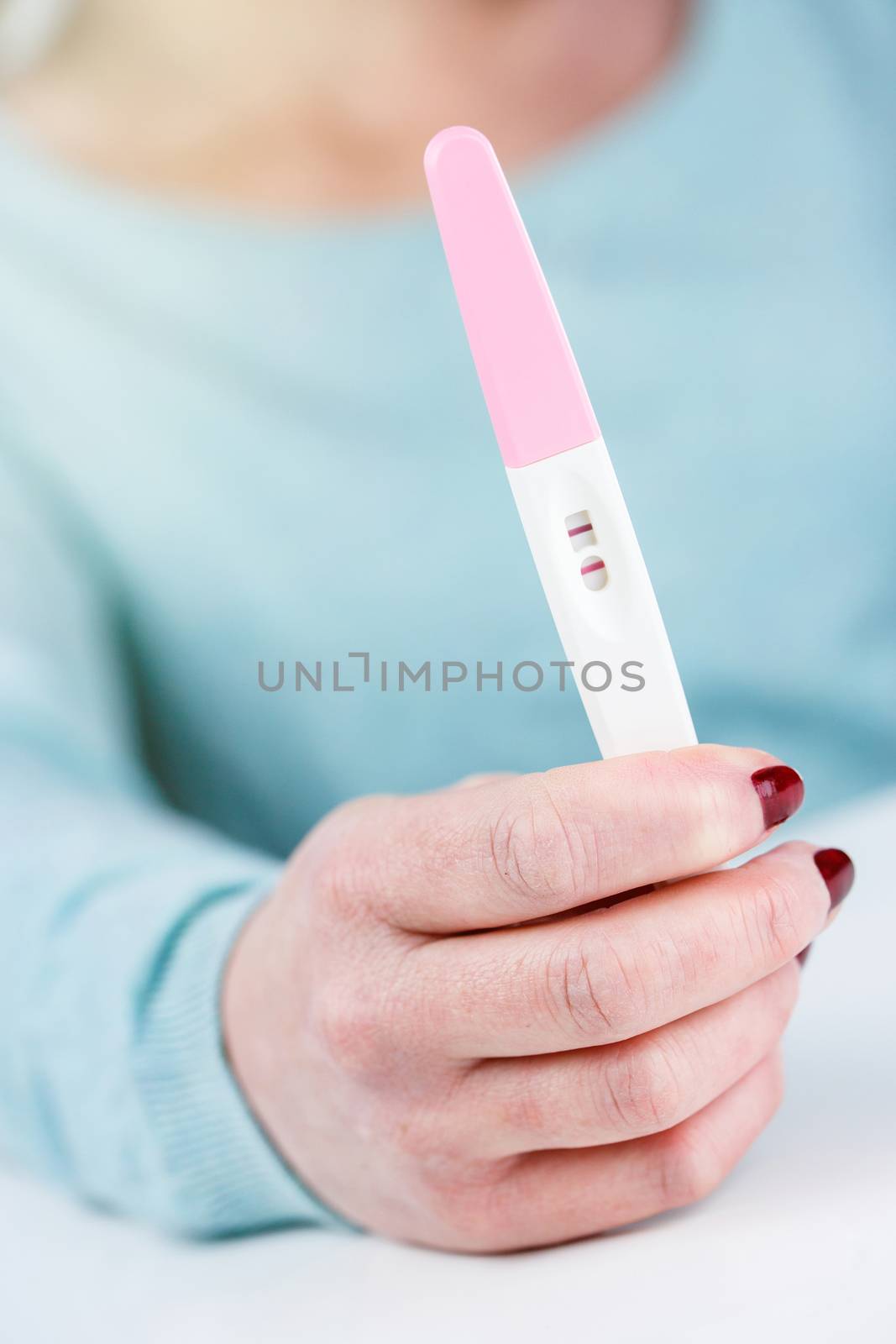 woman holding a Pregnancy Test pregnancy test positive result in her hands