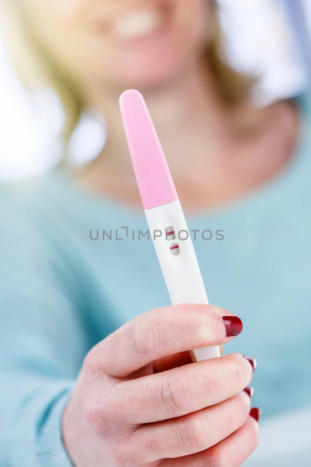 pregnancy test positive result smiling woman by pixinoo