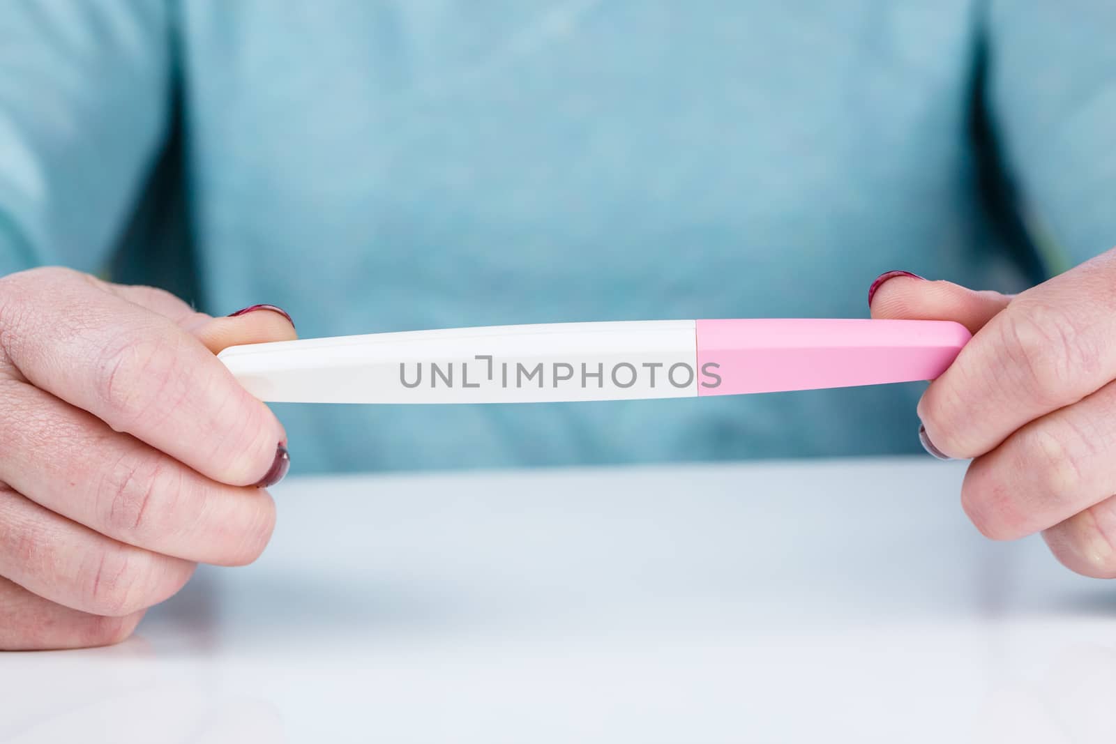 Young woman holding a Pregnancy Test in her hands by pixinoo