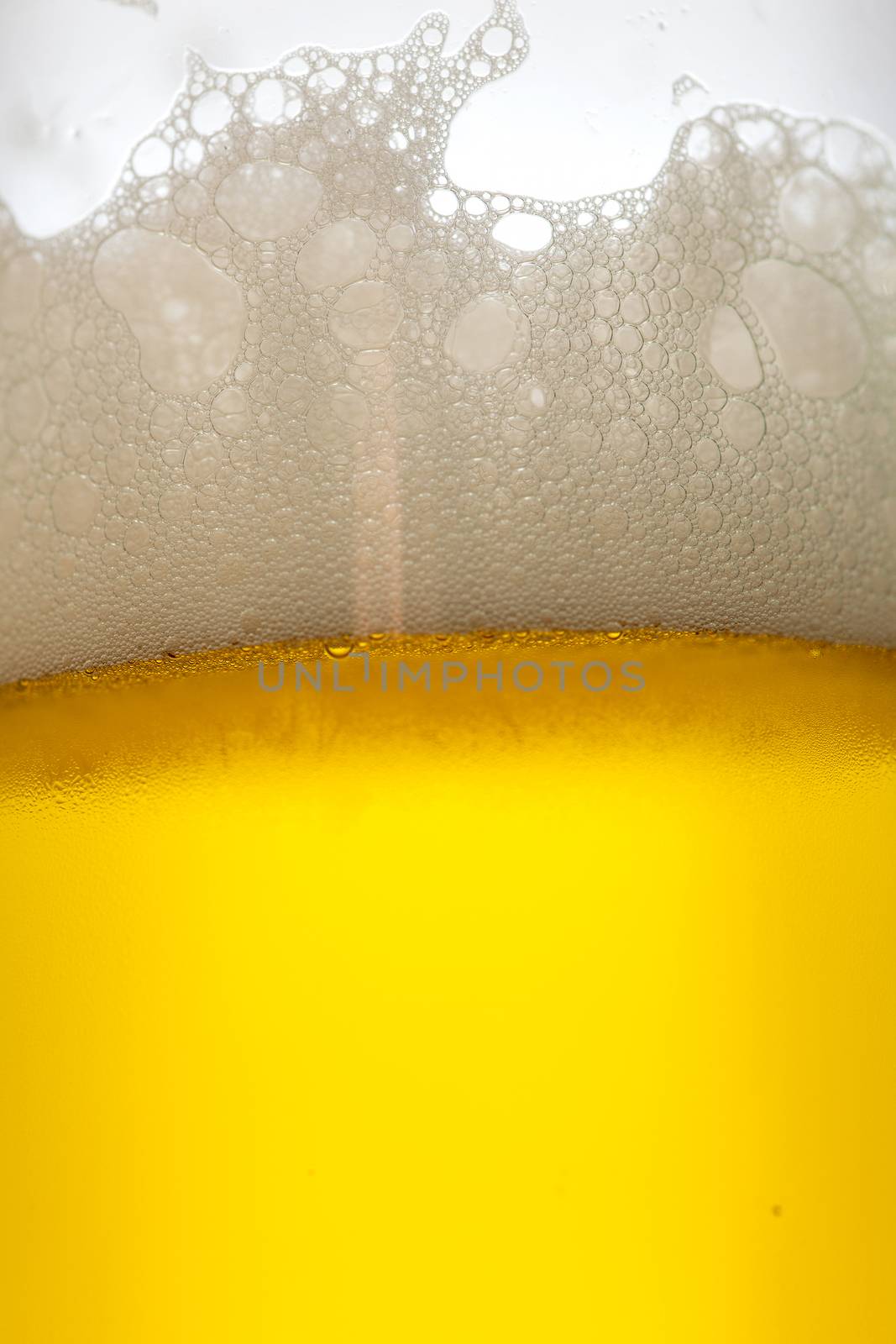 Misted glass of cold drink with foam, close-up
