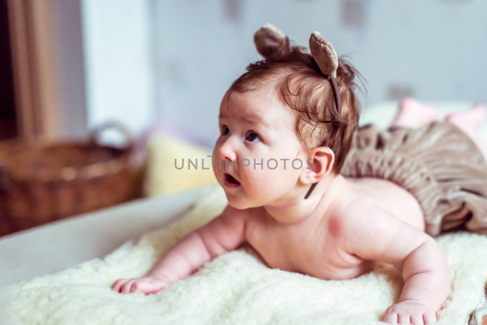 naked baby lying on a soft blanket in the room