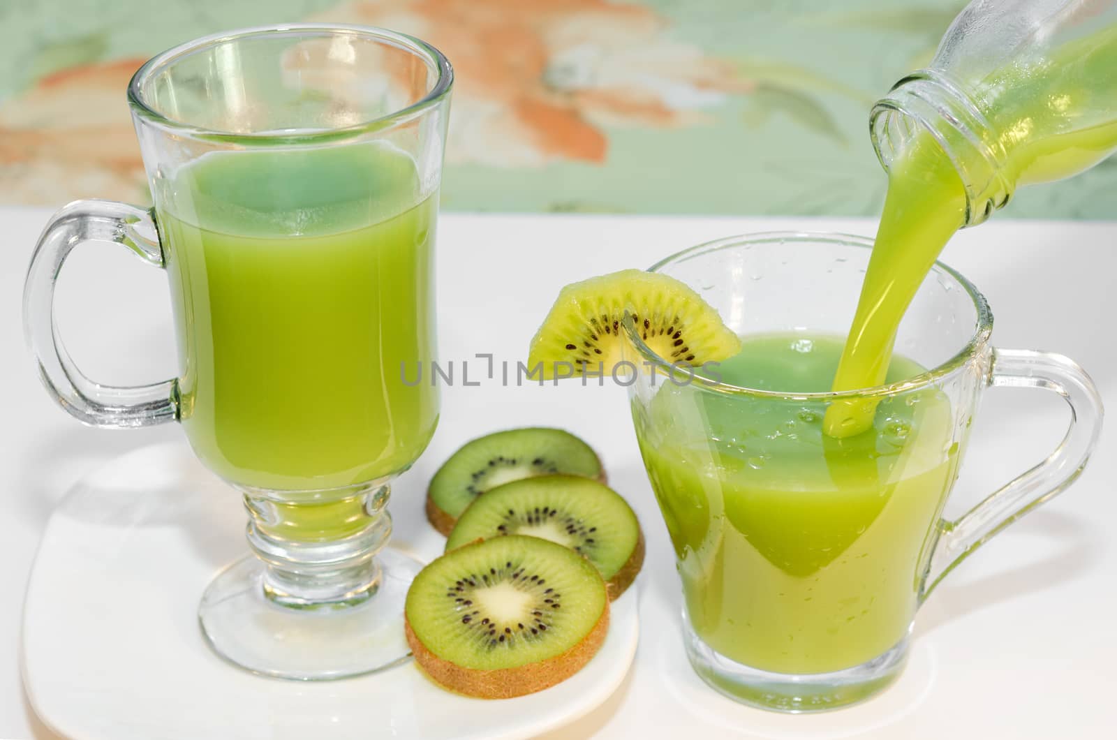 Fresh kiwi juice poured into a Cup from the bottle. Selective focus. by Gaina