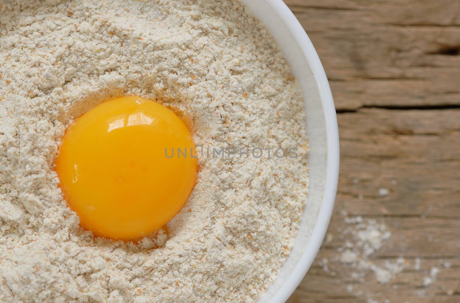 Flour and egg ready for mixing on wooden table